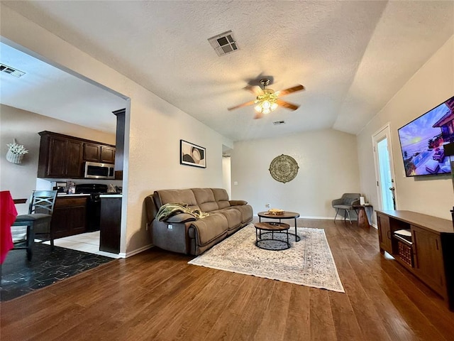 2009 Astoria Dr, Moore, OK 73160 - living room featuring a ceiling fan, wood finished floors, lofted ceiling, baseboards, and a textured ceiling