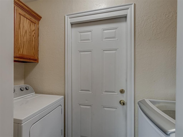 2009 Astoria Dr, Moore, OK 73160 - washroom featuring cabinet space, a textured wall, and washing machine and dryer