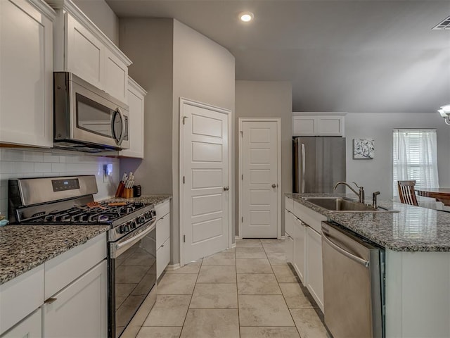 9120 SW 46th St, Oklahoma City, OK 73179 - kitchen with appliances with stainless steel finishes, a sink, white cabinets, an island with sink, and recessed lighting
