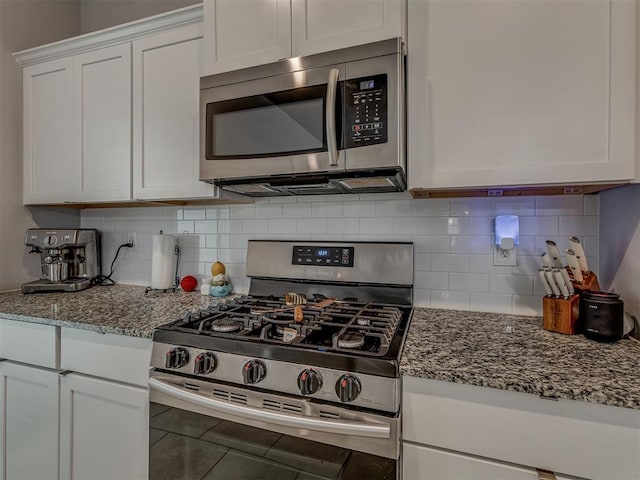 9120 SW 46th St, Oklahoma City, OK 73179 - kitchen with appliances with stainless steel finishes, white cabinets, light stone counters, and tasteful backsplash
