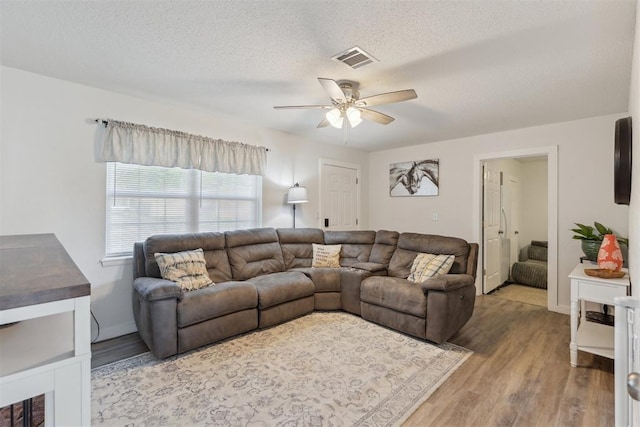 711 Spruce Dr, Yukon, OK 73099 - living area featuring ceiling fan, wood finished floors, and a textured ceiling