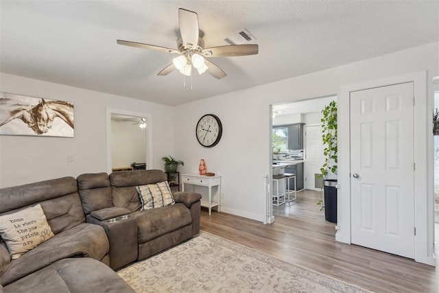 711 Spruce Dr, Yukon, OK 73099 - living area with a ceiling fan, wood finished floors, and baseboards