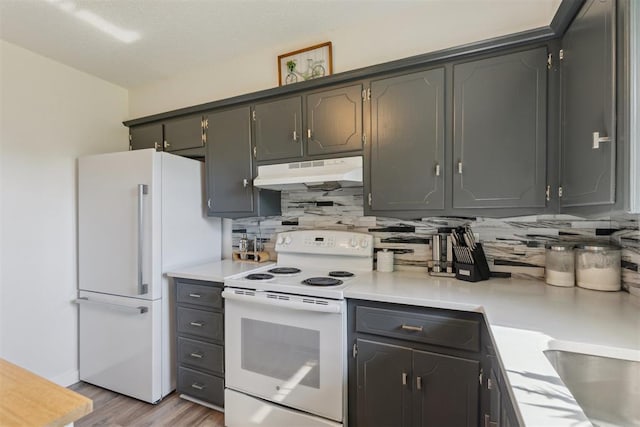 711 Spruce Dr, Yukon, OK 73099 - kitchen with white appliances, under cabinet range hood, backsplash, light wood-type flooring, and light countertops