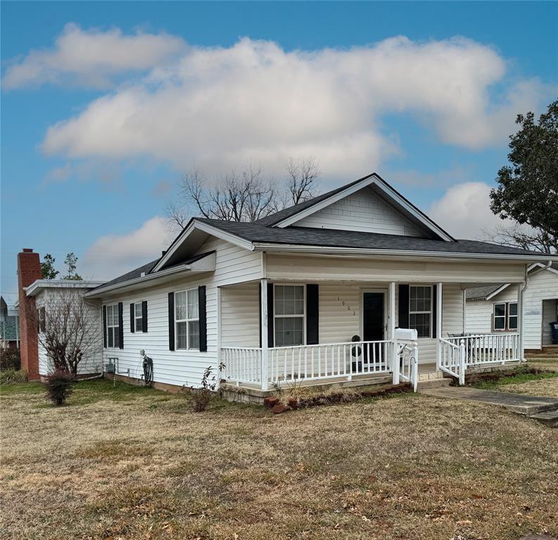 1902 N Park Ave, Shawnee, OK 74804 - view of front of property with a porch, a front yard, and a shingled roof