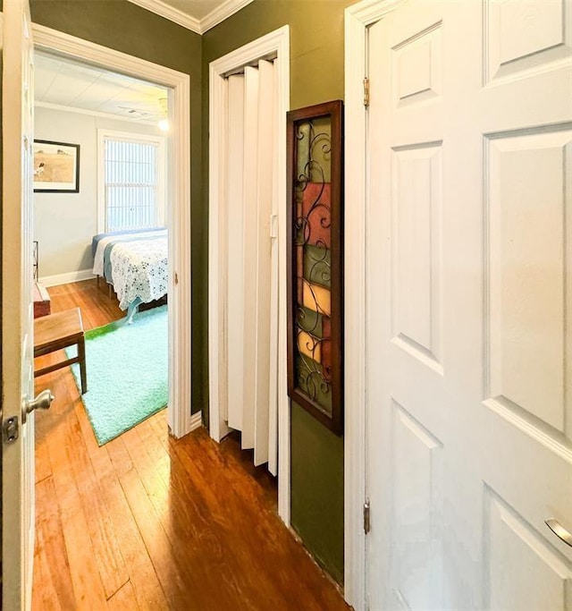 hall with crown molding and wood finished floors