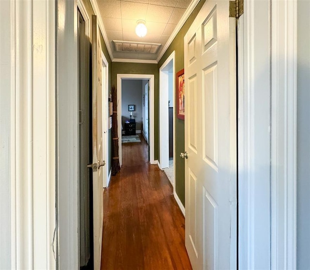 corridor with crown molding, dark wood finished floors, and baseboards