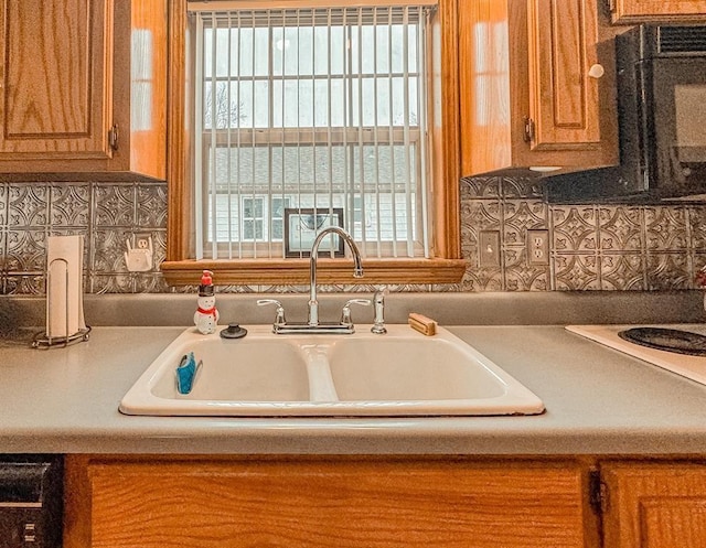 kitchen featuring a sink, brown cabinets, tasteful backsplash, and light countertops
