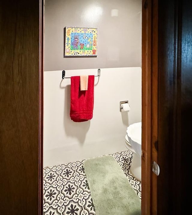 bathroom featuring toilet and tile patterned flooring