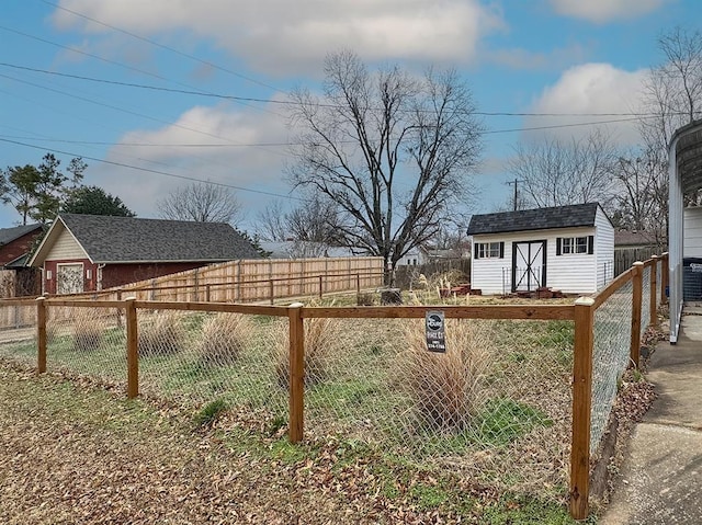 fenced yard with a shed, an outbuilding, and central air condition unit