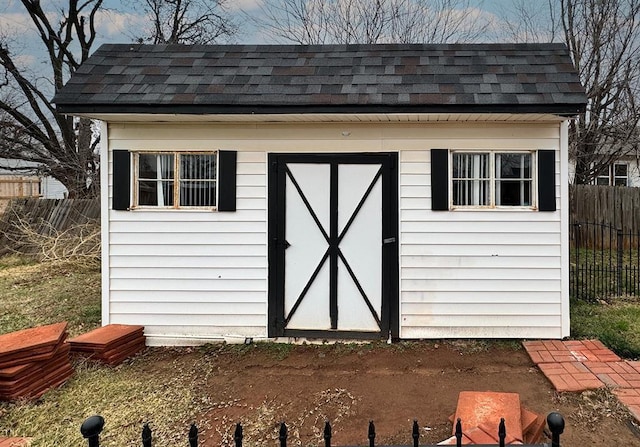 view of shed featuring fence