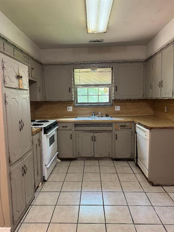 3316 Beechwood Dr, Del City, OK 73115 - kitchen featuring white appliances, a sink, gray cabinets, light tile patterned floors, and backsplash