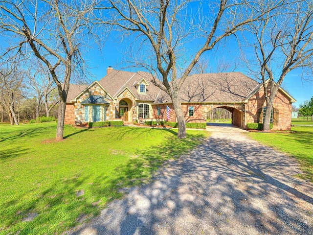 view of front of home with driveway, a chimney, a front lawn, and a carport