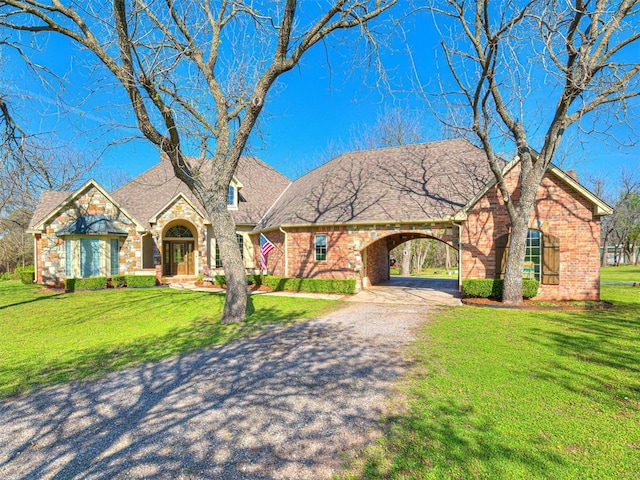 view of front of house with driveway, a carport, a front yard, and brick siding
