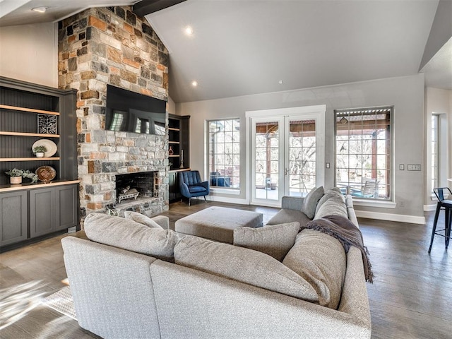 living area with plenty of natural light, a fireplace, baseboards, beamed ceiling, and wood finished floors
