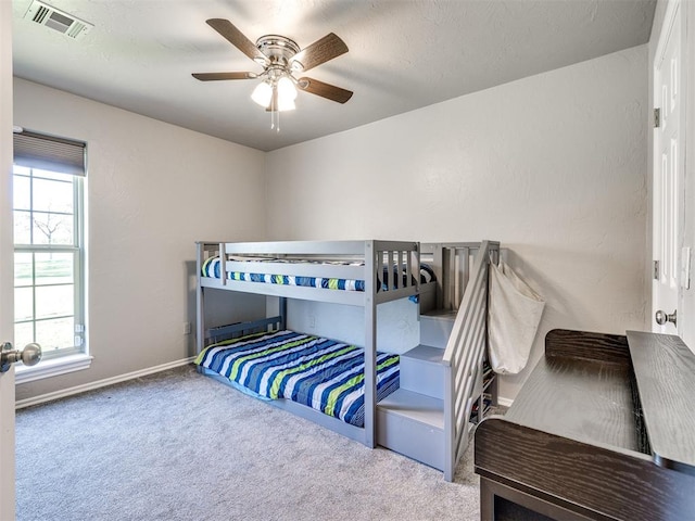 carpeted bedroom featuring baseboards and ceiling fan