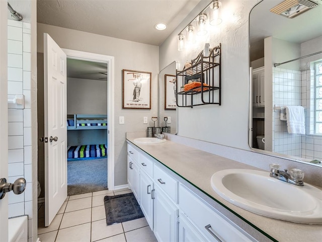 bathroom featuring double vanity, a shower, and tile patterned floors