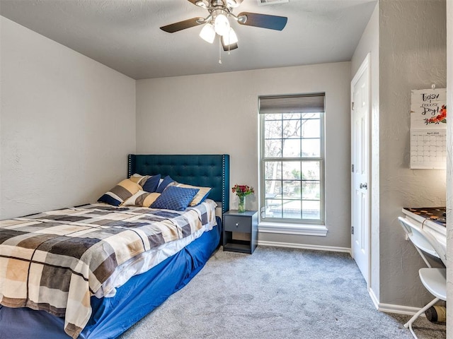 bedroom featuring a textured wall, carpet, ceiling fan, and baseboards