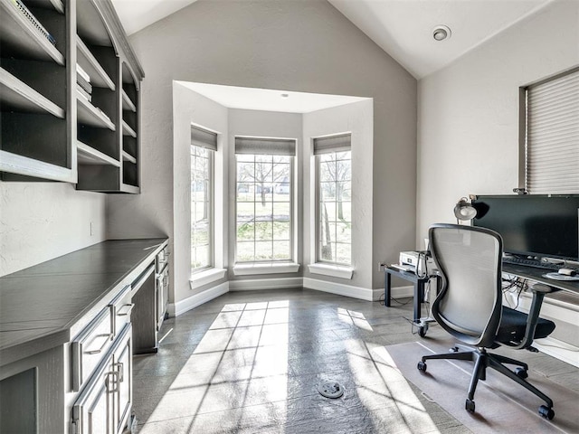 office with lofted ceiling and baseboards