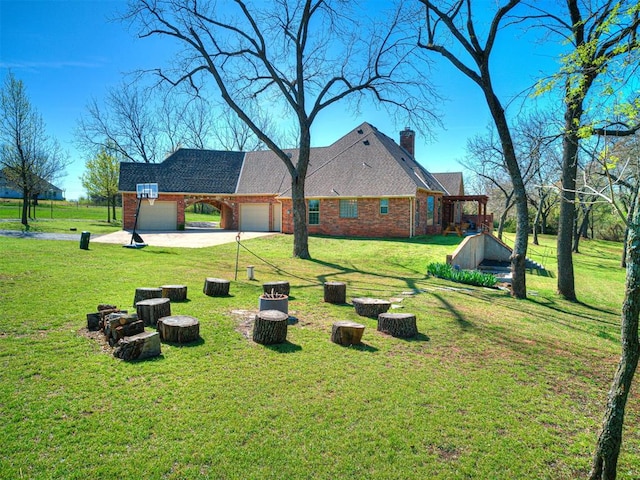view of green lawn featuring a garage and driveway