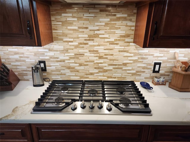 11301 Brockton Pl, Oklahoma City, OK 73162 - kitchen view of stainless steel gas stovetop, backsplash, light countertops, and dark brown cabinetry