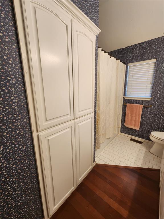 11301 Brockton Pl, Oklahoma City, OK 73162 - bathroom with hardwood / wood-style flooring, toilet, wallpapered walls, and a shower with curtain