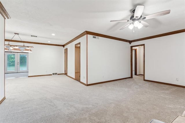 empty room with baseboards, crown molding, light colored carpet, ceiling fan, and french doors