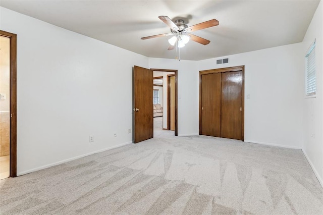 unfurnished bedroom featuring light carpet, a closet, and baseboards