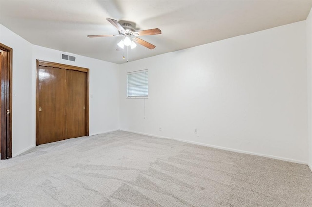 unfurnished bedroom featuring light colored carpet, baseboards, and a ceiling fan