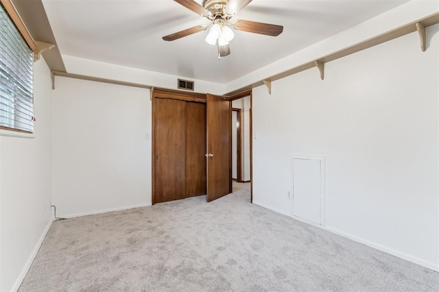 unfurnished bedroom with light colored carpet, baseboards, and ceiling fan