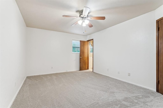 unfurnished room with light carpet, a ceiling fan, and baseboards
