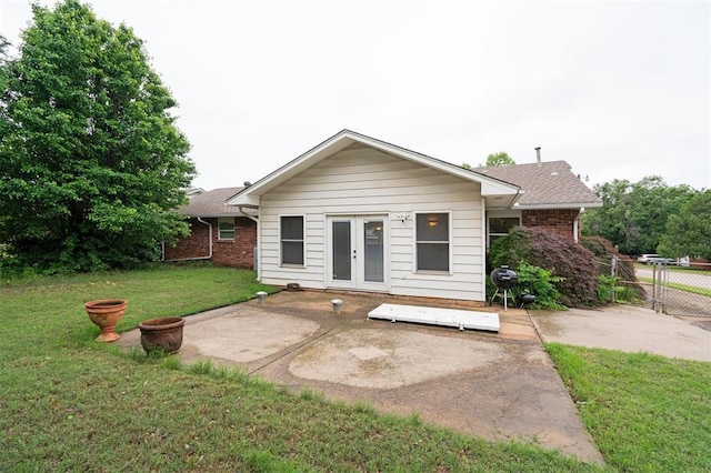 back of house featuring french doors, a patio area, brick siding, and roof with shingles