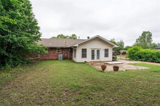rear view of house featuring french doors, cooling unit, a patio, and a yard