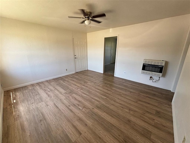 1011 E Sutherland St, Altus, OK 73521 - unfurnished room featuring heating unit, wood finished floors, a ceiling fan, and baseboards