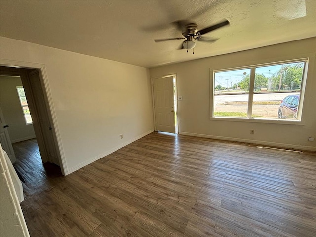1011 E Sutherland St, Altus, OK 73521 - unfurnished room with dark wood finished floors, baseboards, and a ceiling fan