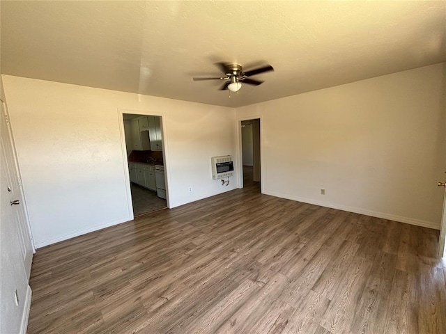 1011 E Sutherland St, Altus, OK 73521 - unfurnished room featuring dark wood finished floors, ceiling fan, heating unit, and baseboards