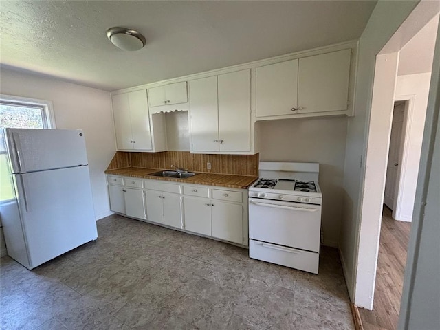 1011 E Sutherland St, Altus, OK 73521 - kitchen featuring white appliances, a sink, white cabinets, and decorative backsplash