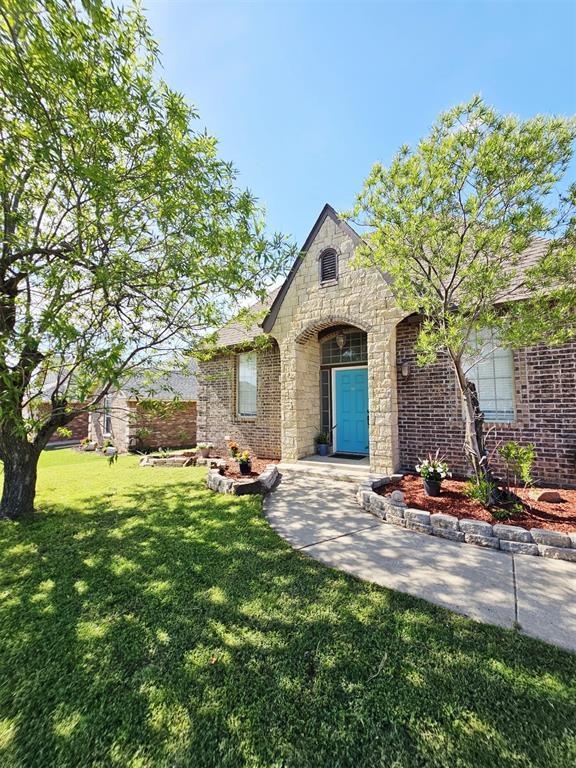 12401 SW 7th St, Yukon, OK 73099 - view of front of home featuring stone siding, a front yard, and brick siding