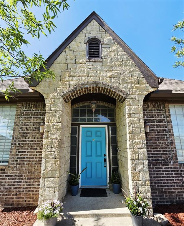 12401 SW 7th St, Yukon, OK 73099 - entrance to property with stone siding, brick siding, and a shingled roof