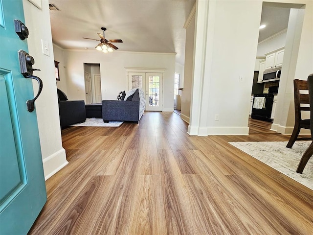 12401 SW 7th St, Yukon, OK 73099 - living room with ornamental molding, a ceiling fan, baseboards, and wood finished floors