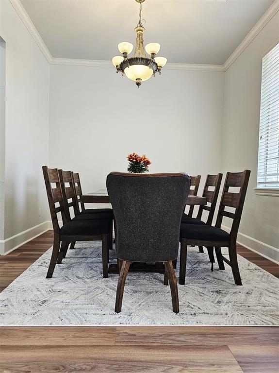 12401 SW 7th St, Yukon, OK 73099 - dining room featuring baseboards, a chandelier, ornamental molding, and wood finished floors