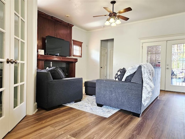 12401 SW 7th St, Yukon, OK 73099 - living area featuring french doors, wood finished floors, crown molding, a ceiling fan, and a fireplace