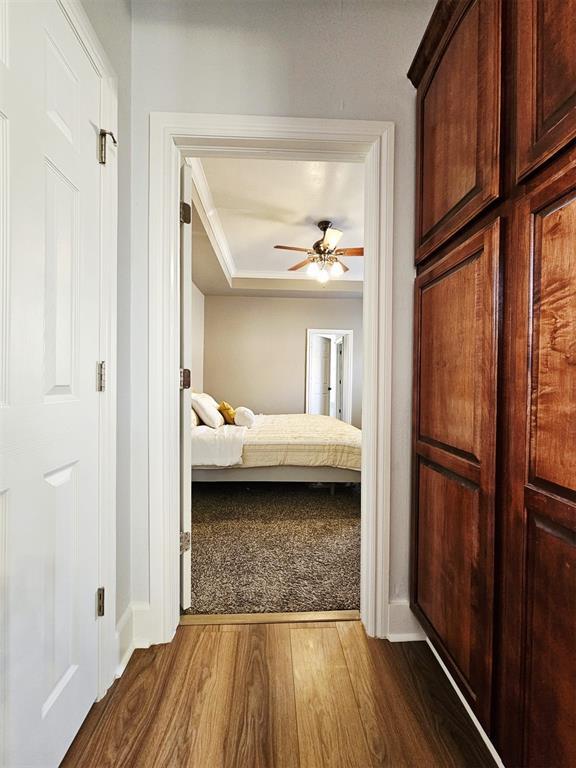 12401 SW 7th St, Yukon, OK 73099 - bedroom with dark wood-style flooring, baseboards, a tray ceiling, and ceiling fan