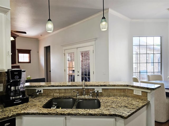 12401 SW 7th St, Yukon, OK 73099 - kitchen with a sink, white cabinets, dark stone countertops, french doors, and crown molding