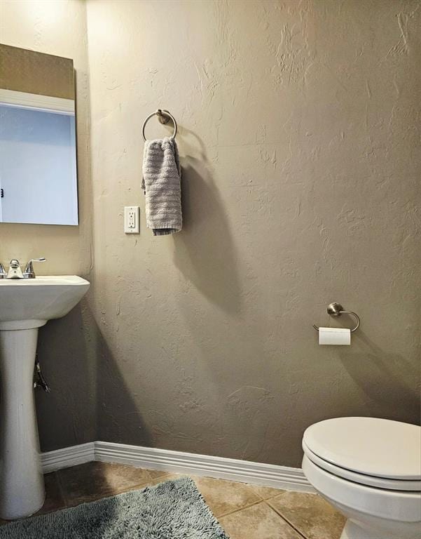 12401 SW 7th St, Yukon, OK 73099 - half bathroom featuring tile patterned flooring, baseboards, toilet, and a sink