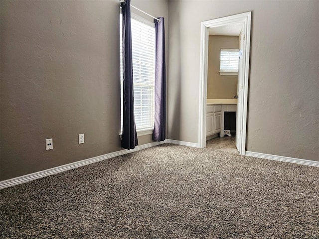 12401 SW 7th St, Yukon, OK 73099 - unfurnished bedroom featuring carpet floors, a textured wall, ensuite bathroom, and baseboards