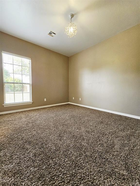 12401 SW 7th St, Yukon, OK 73099 - empty room with a chandelier, baseboards, and carpet