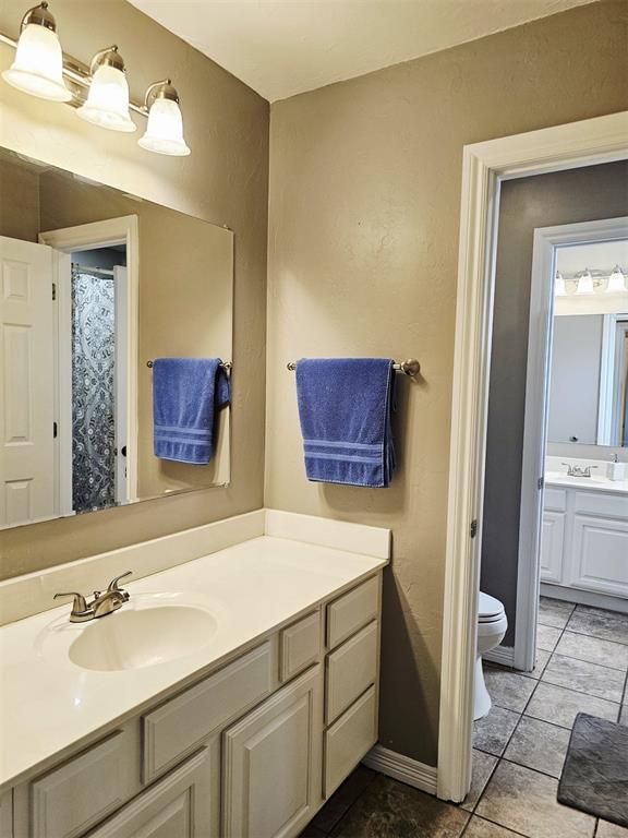 12401 SW 7th St, Yukon, OK 73099 - bathroom featuring toilet, vanity, and tile patterned flooring