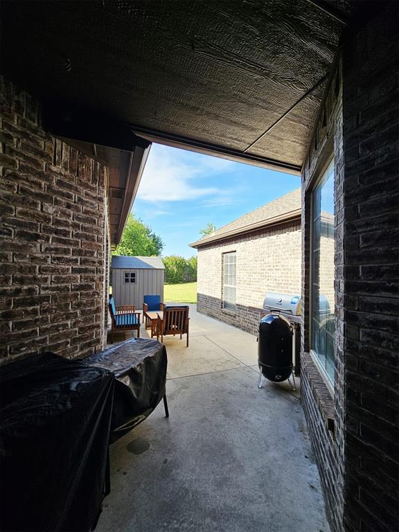 12401 SW 7th St, Yukon, OK 73099 - view of patio / terrace featuring a shed and an outbuilding