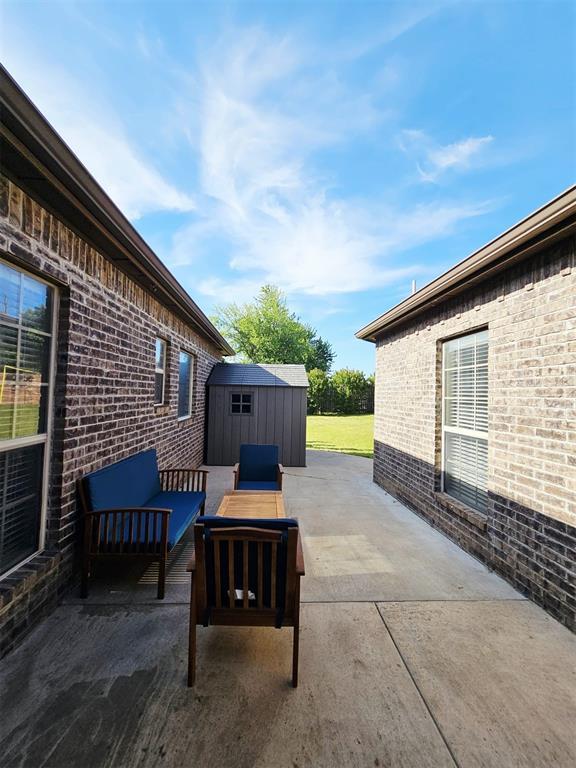 12401 SW 7th St, Yukon, OK 73099 - view of patio / terrace with a storage unit, an outbuilding, and outdoor lounge area
