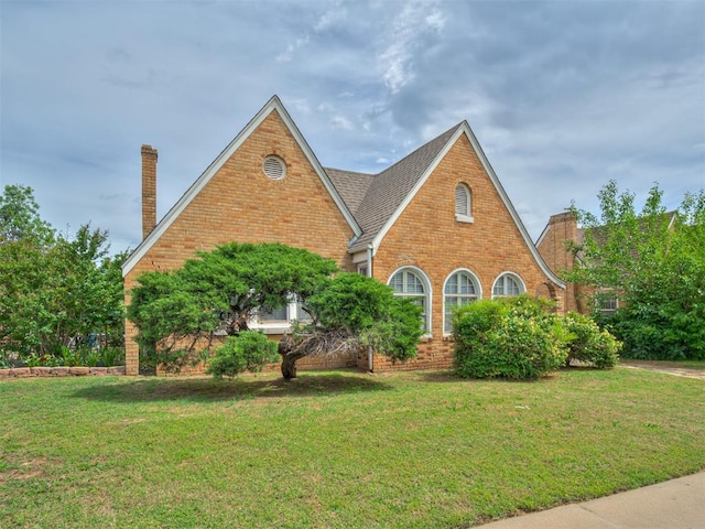 2617 NW 23rd St, Oklahoma City, OK 73107 - tudor-style house with a chimney, brick siding, and a front yard